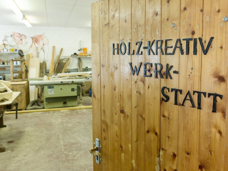 Eingangstür mit der Aufschrift: "Holz-Kreativ-Werkstatt"